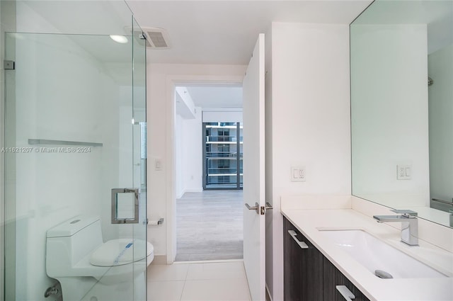 bathroom featuring vanity, tile patterned floors, and toilet