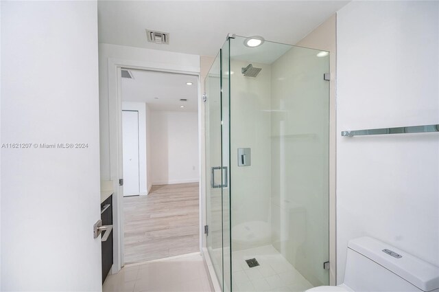 bathroom featuring vanity, tile patterned flooring, a shower with shower door, and toilet