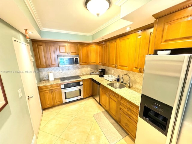 kitchen featuring sink, appliances with stainless steel finishes, a tray ceiling, and decorative backsplash