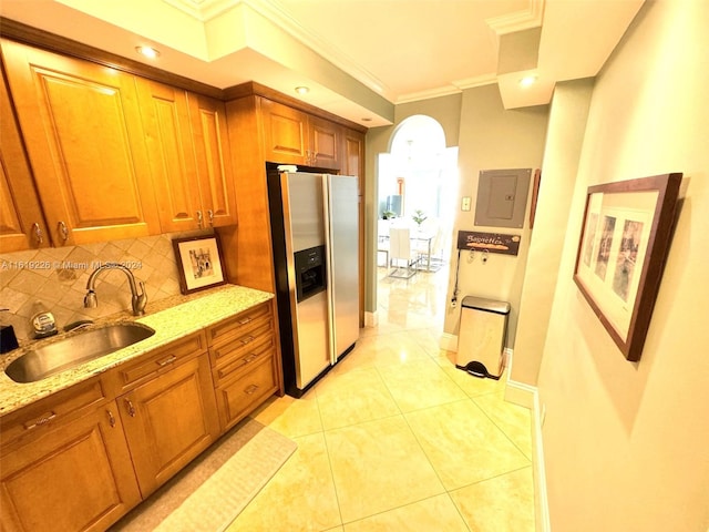 kitchen featuring light tile patterned floors, light stone counters, decorative backsplash, stainless steel fridge, and sink