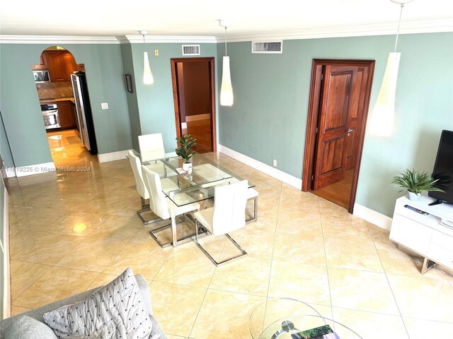 interior space with light tile patterned flooring and ornamental molding