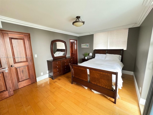 bedroom with light wood-type flooring and crown molding