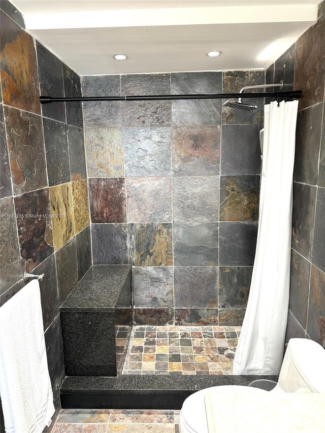 bathroom featuring a shower with shower curtain and toilet