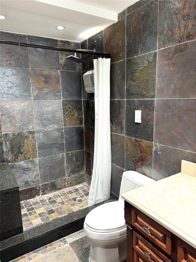 bathroom with walk in shower, tile patterned flooring, toilet, vanity, and tile walls