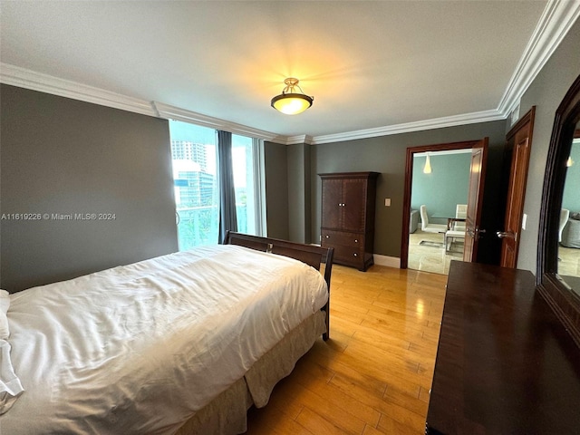 bedroom featuring crown molding and wood-type flooring