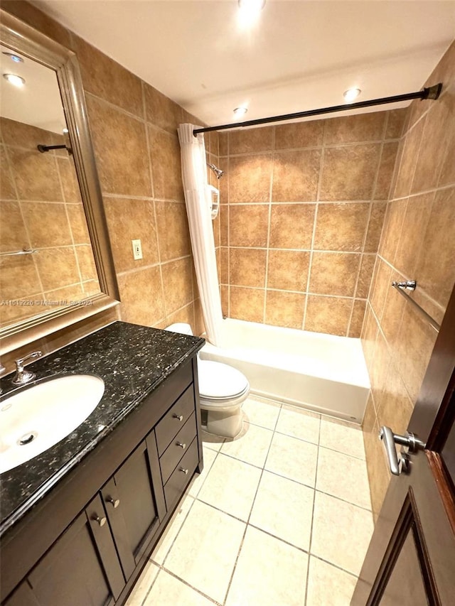 bathroom with toilet, tile walls, tile patterned flooring, and vanity