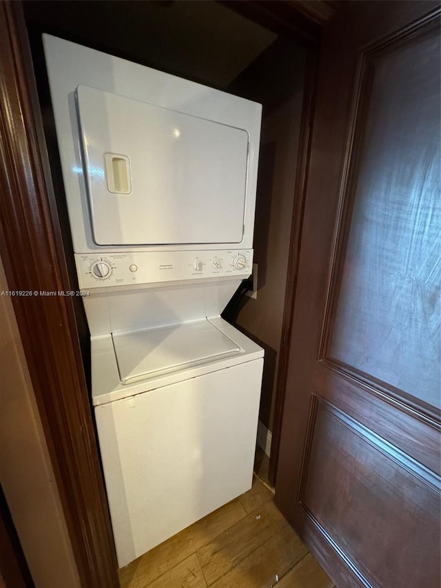 clothes washing area with stacked washer / dryer and hardwood / wood-style floors