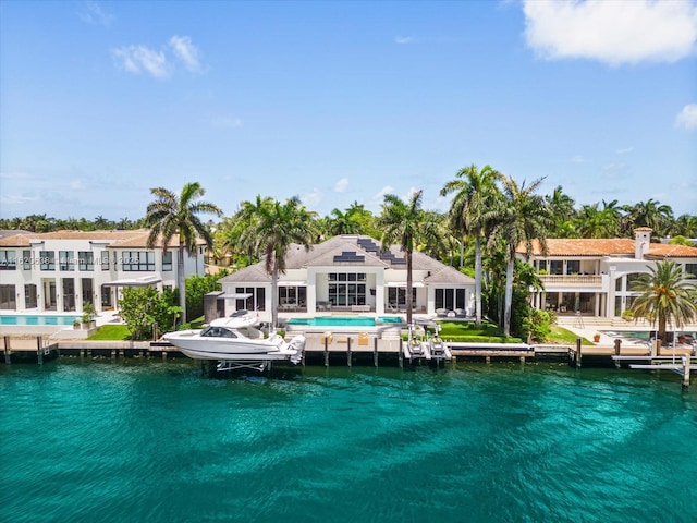 rear view of house with a water view and an outdoor pool