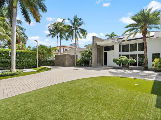 exterior space featuring curved driveway and a yard