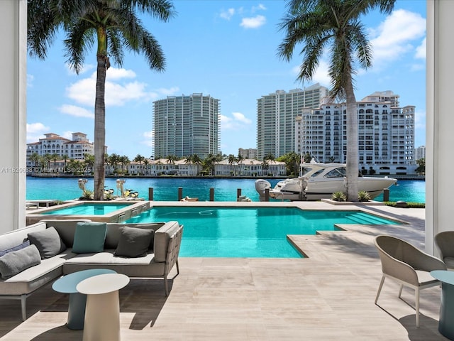 pool featuring a water view, a city view, and an in ground hot tub