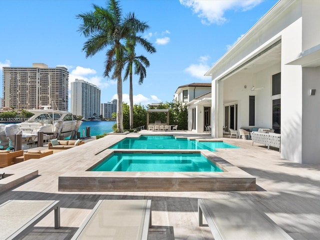 view of pool with a water view, an in ground hot tub, and a patio area