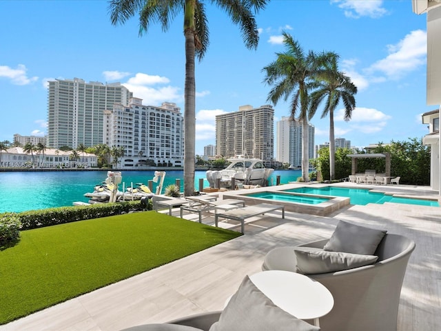 community pool featuring a hot tub, a lawn, a water view, a city view, and a patio area