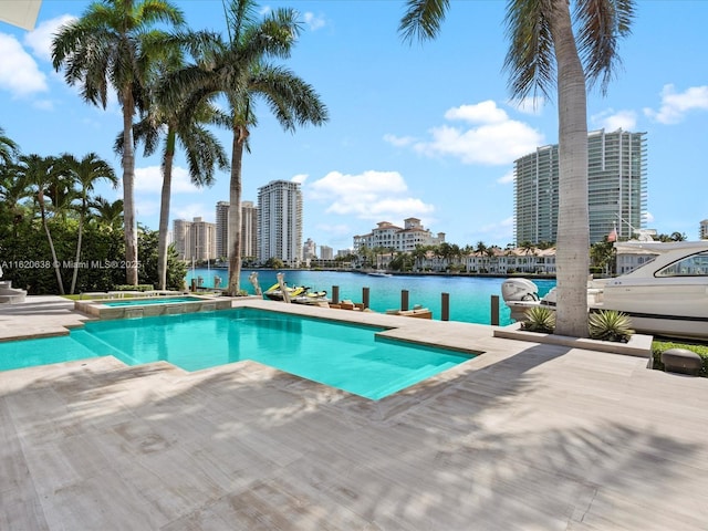 view of swimming pool featuring a view of city, a pool with connected hot tub, and a water view