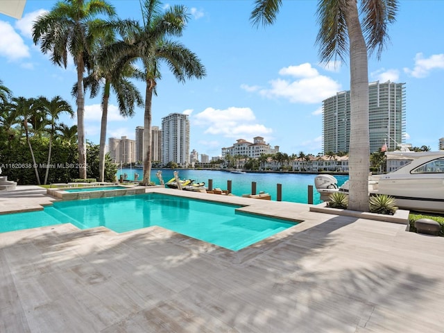 view of pool with a water view, a pool with connected hot tub, and a patio area