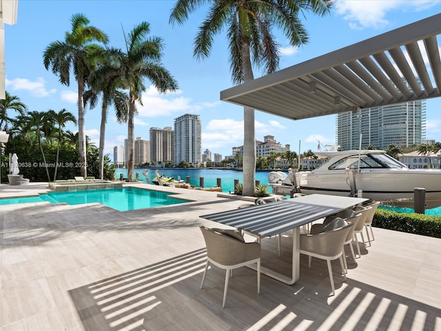outdoor pool with a water view, a city view, and a patio area