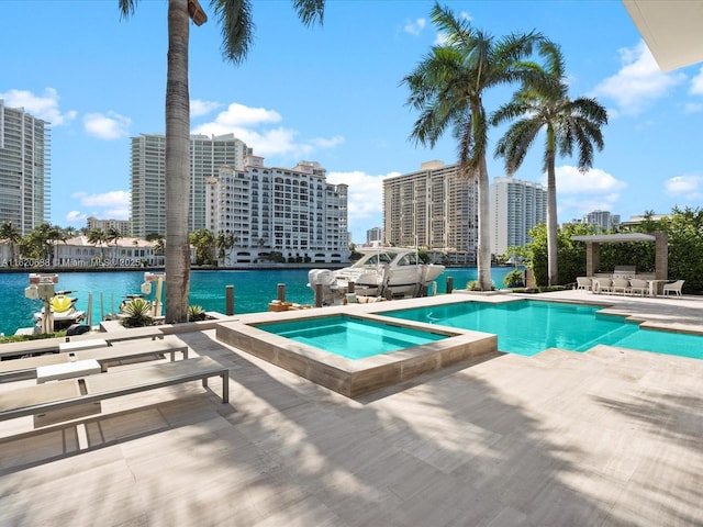 outdoor pool featuring a patio, a water view, an in ground hot tub, and a city view