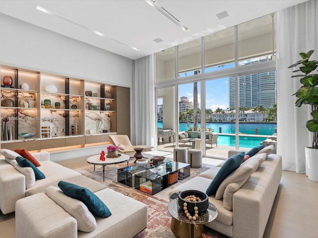 living room with a water view and a high ceiling