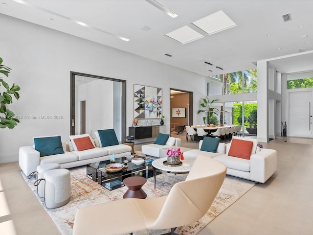 living room featuring a skylight and visible vents