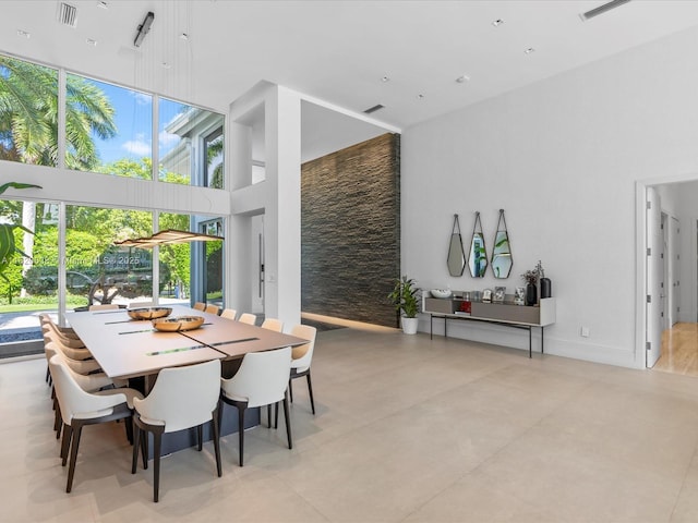 dining area with visible vents and a towering ceiling