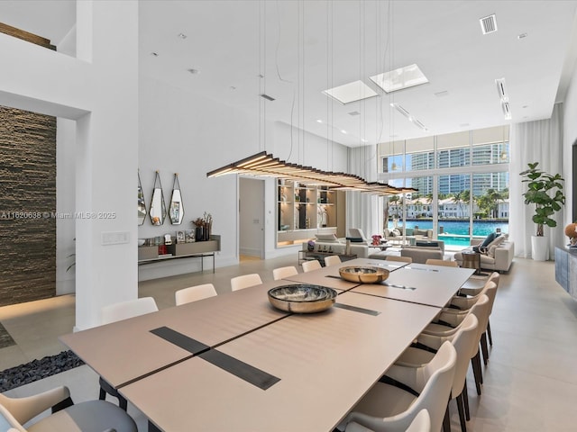 dining room with a high ceiling, expansive windows, and visible vents