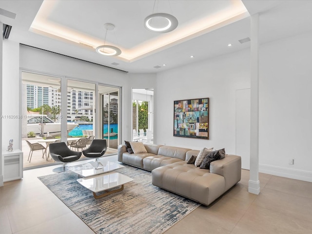 living area with a raised ceiling, baseboards, and recessed lighting