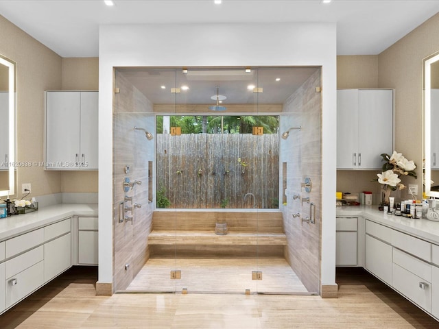 full bathroom featuring vanity, a shower stall, and wood finished floors