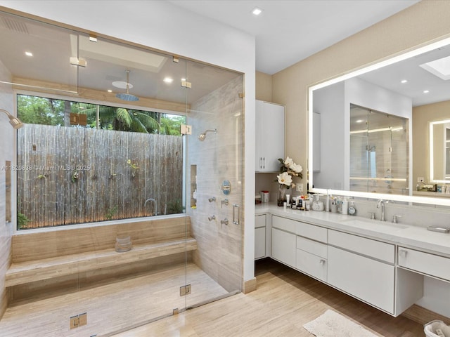 bathroom featuring a stall shower, a healthy amount of sunlight, vanity, and wood finished floors