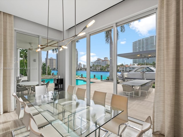 dining space featuring a water view, a city view, and wood finished floors