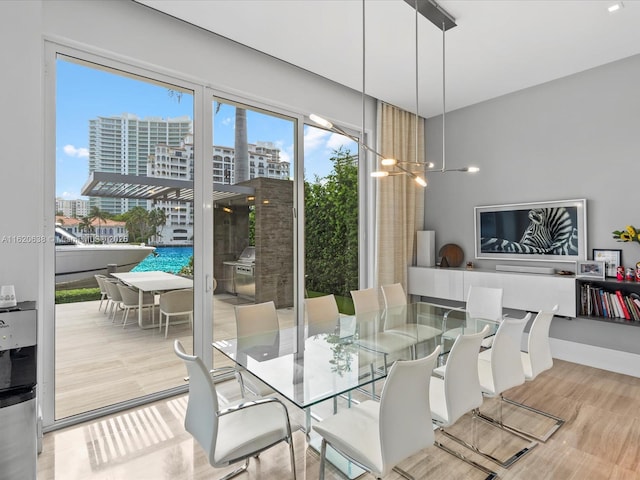 dining space featuring a notable chandelier, a city view, and wood finished floors