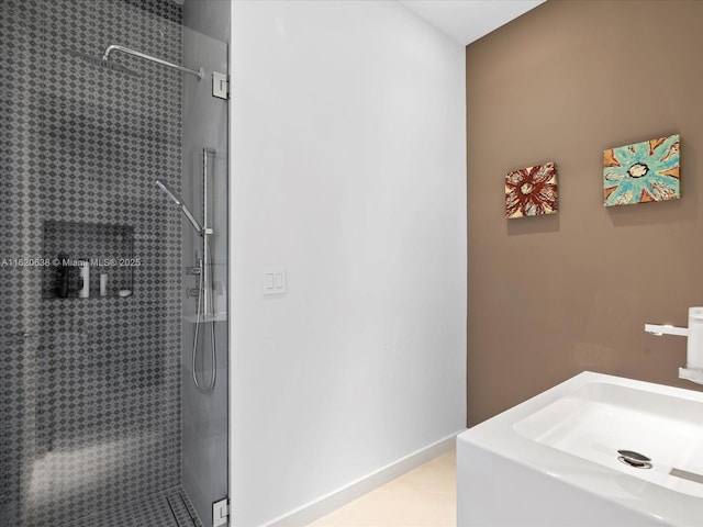 bathroom with a sink and a tile shower