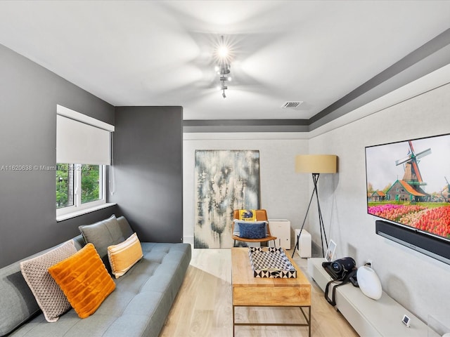 living room featuring visible vents and wood finished floors