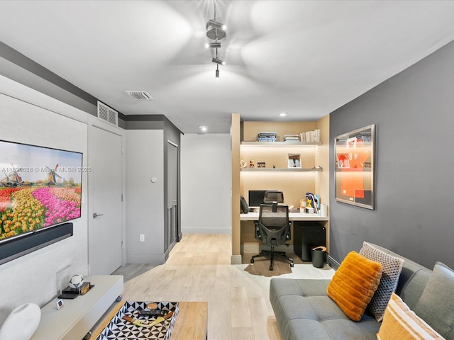 office area with light wood finished floors and visible vents