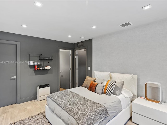 bedroom with light wood-type flooring, baseboards, visible vents, and recessed lighting