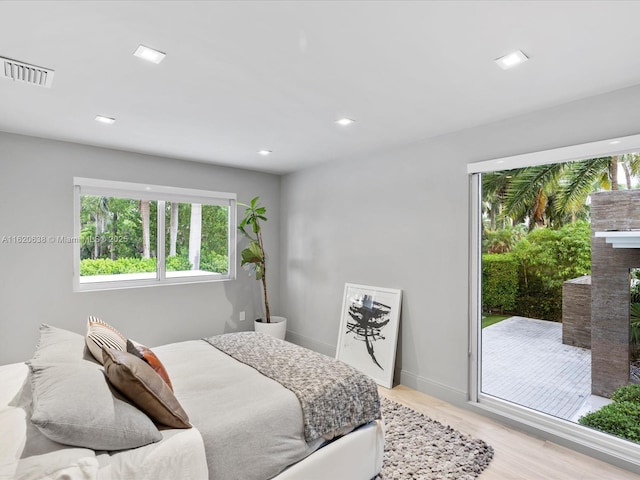bedroom featuring visible vents, a fireplace, baseboards, light wood finished floors, and recessed lighting