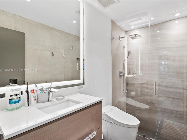 bathroom with toilet, recessed lighting, vanity, visible vents, and a shower stall