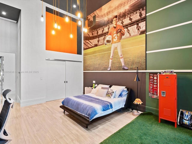 bedroom featuring baseboards, wood finished floors, and a closet
