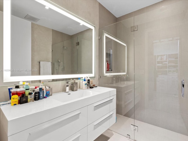 bathroom with visible vents, backsplash, a shower stall, and vanity