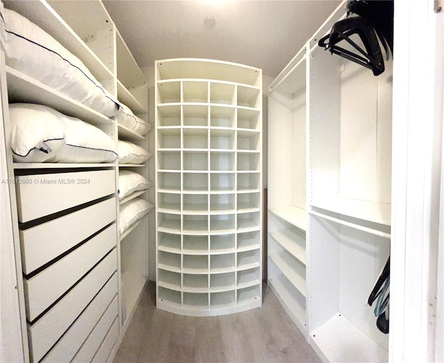 walk in closet with hardwood / wood-style floors