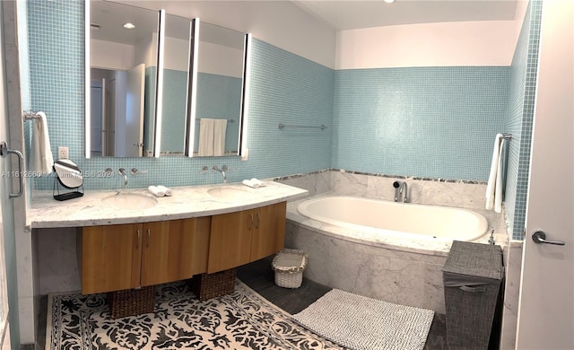 bathroom with vanity, tile patterned floors, and tiled tub