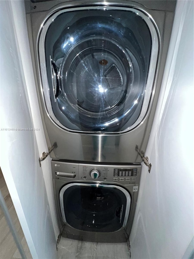 clothes washing area with stacked washer and clothes dryer