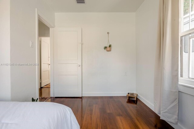 bedroom with dark hardwood / wood-style floors