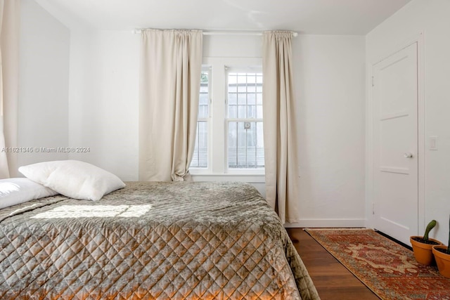 bedroom with multiple windows and hardwood / wood-style floors