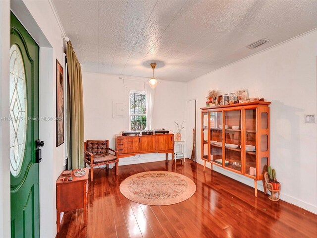 living area featuring ornamental molding and hardwood / wood-style floors