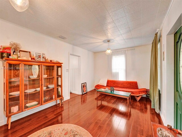 sitting room featuring wood-type flooring and ornamental molding