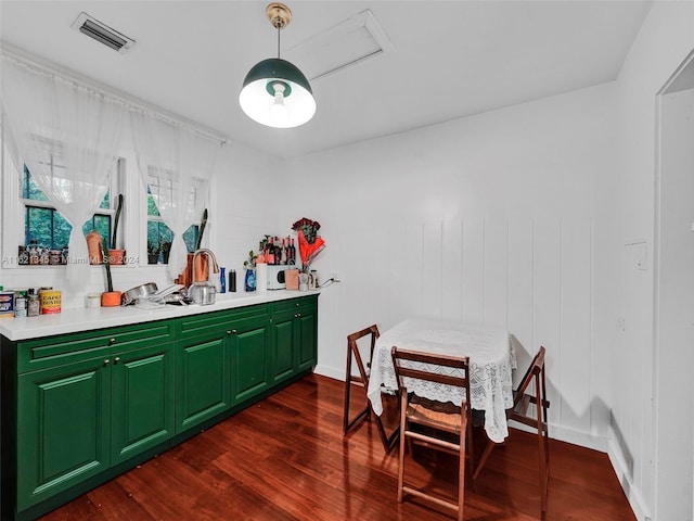 bar featuring dark hardwood / wood-style flooring and green cabinetry