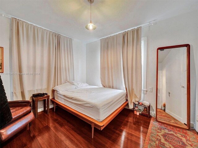 bedroom with dark hardwood / wood-style flooring