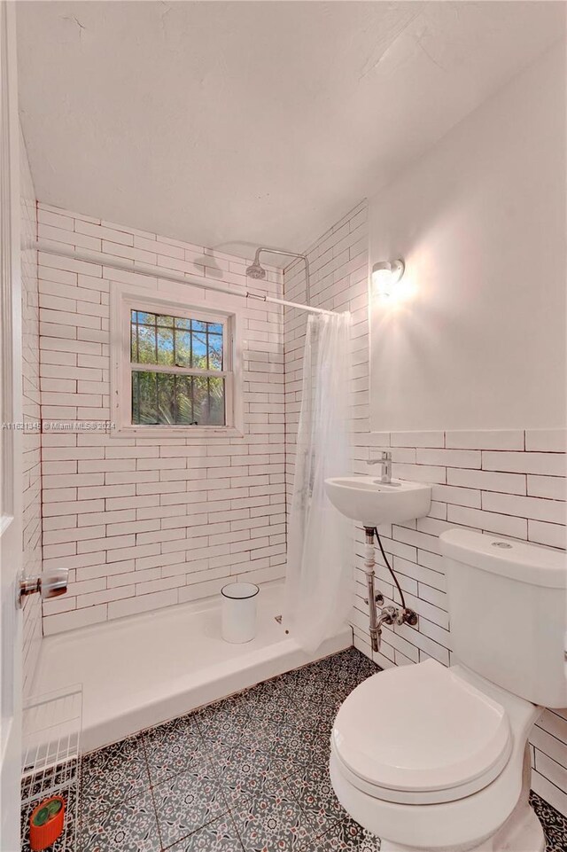 full bathroom with shower / bathtub combination with curtain, tile walls, toilet, tile patterned flooring, and backsplash