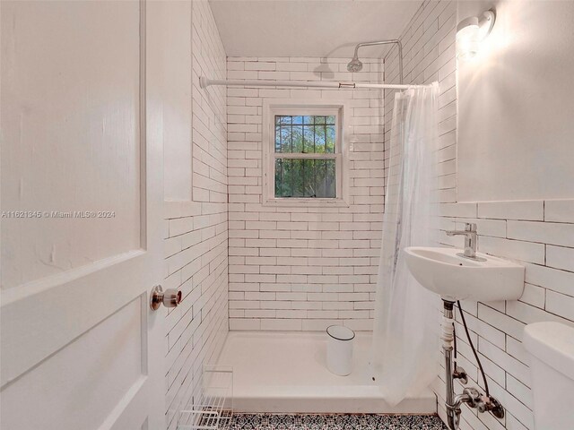 full bathroom featuring shower / bathtub combination with curtain, tile walls, decorative backsplash, sink, and toilet