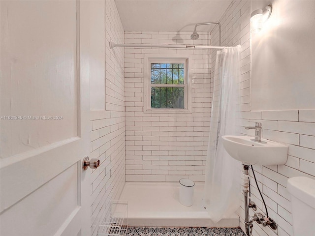 bathroom with toilet, tile walls, sink, and a shower with shower curtain