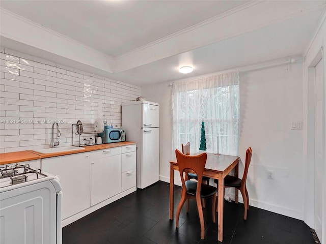 kitchen featuring white cabinetry, wooden counters, white appliances, crown molding, and sink